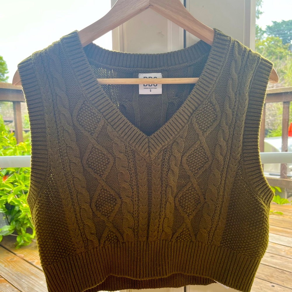 This is a sweater vest in kaki colored. It’s a great layering piece!